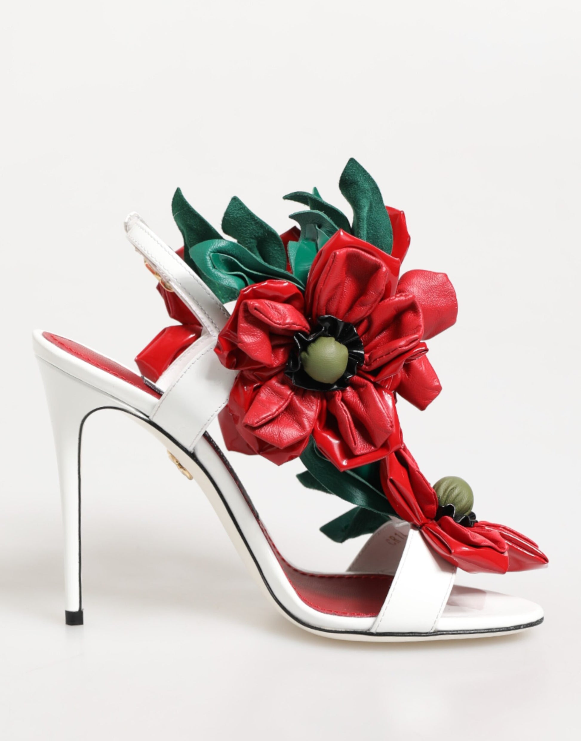 White high-heeled shoe with a red floral design on a white background