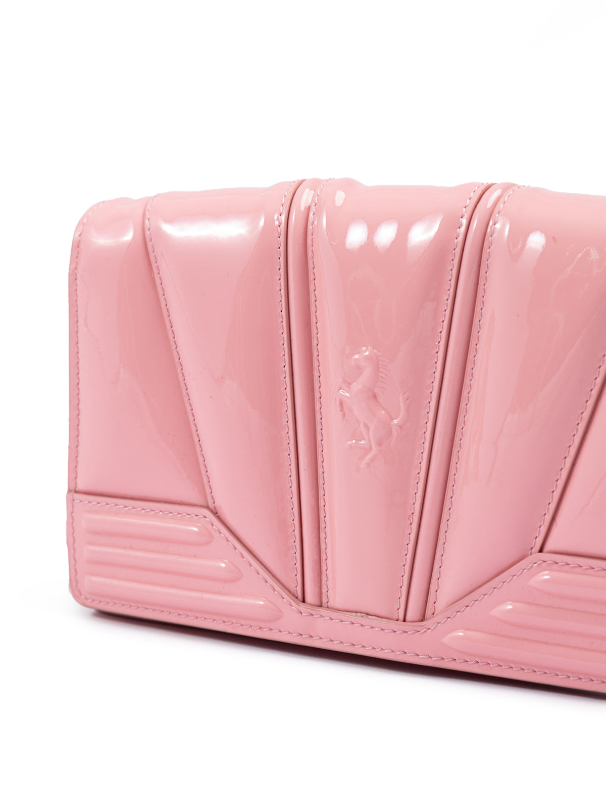 Pink patent leather handbag with a brand logo on a white background