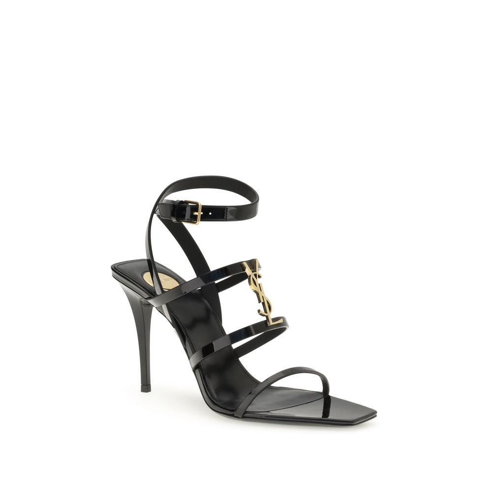 Black high-heeled sandal with gold accents on a white background