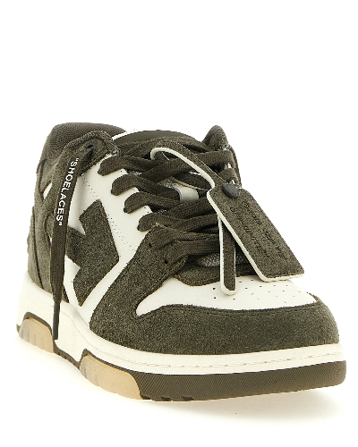 A low-top sneaker by ShoeLaces in dark olive green suede and off-white leather, featuring a white midsole and a gum outsole.
