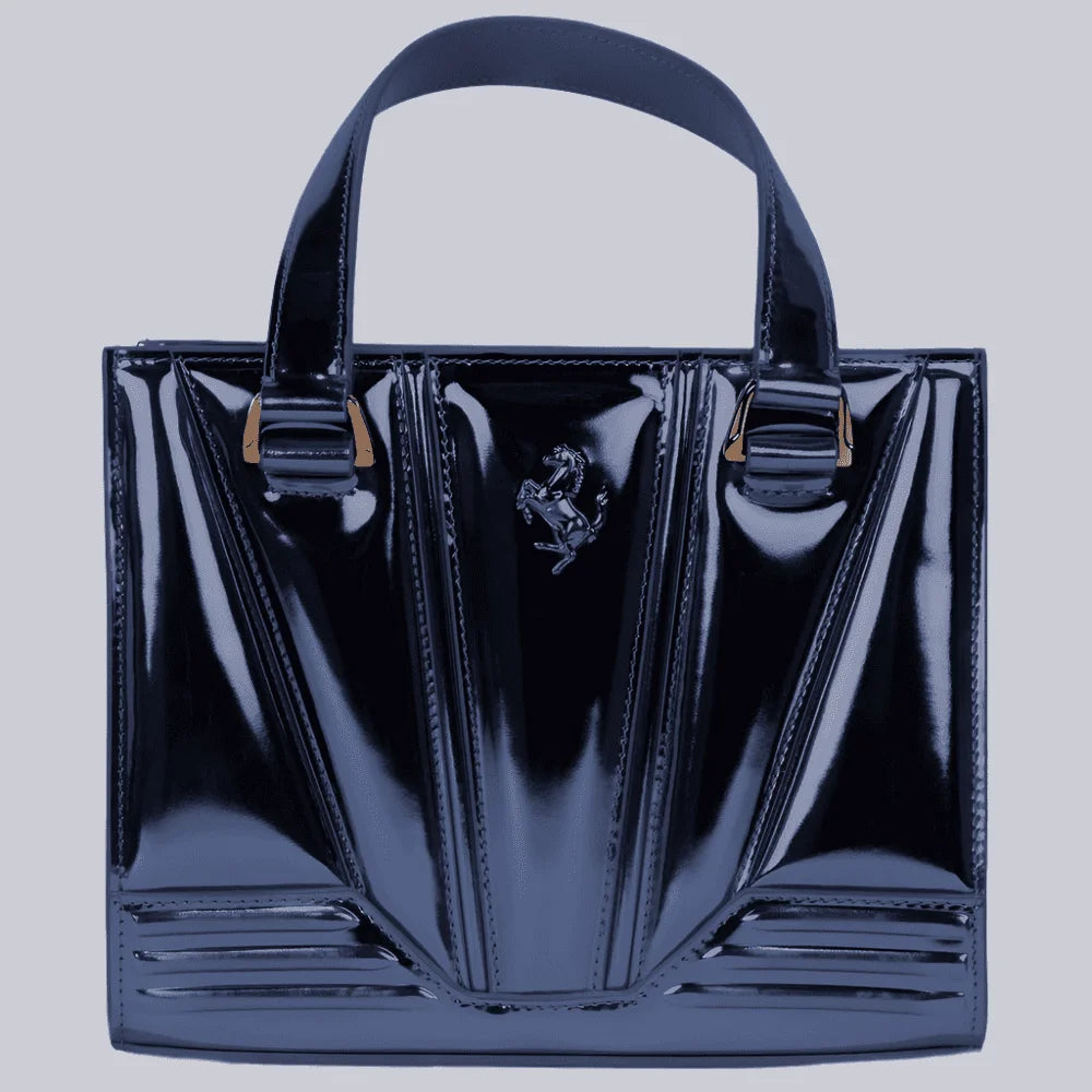 Black Ferrari patent leather handbag with a brand logo on a light gray background