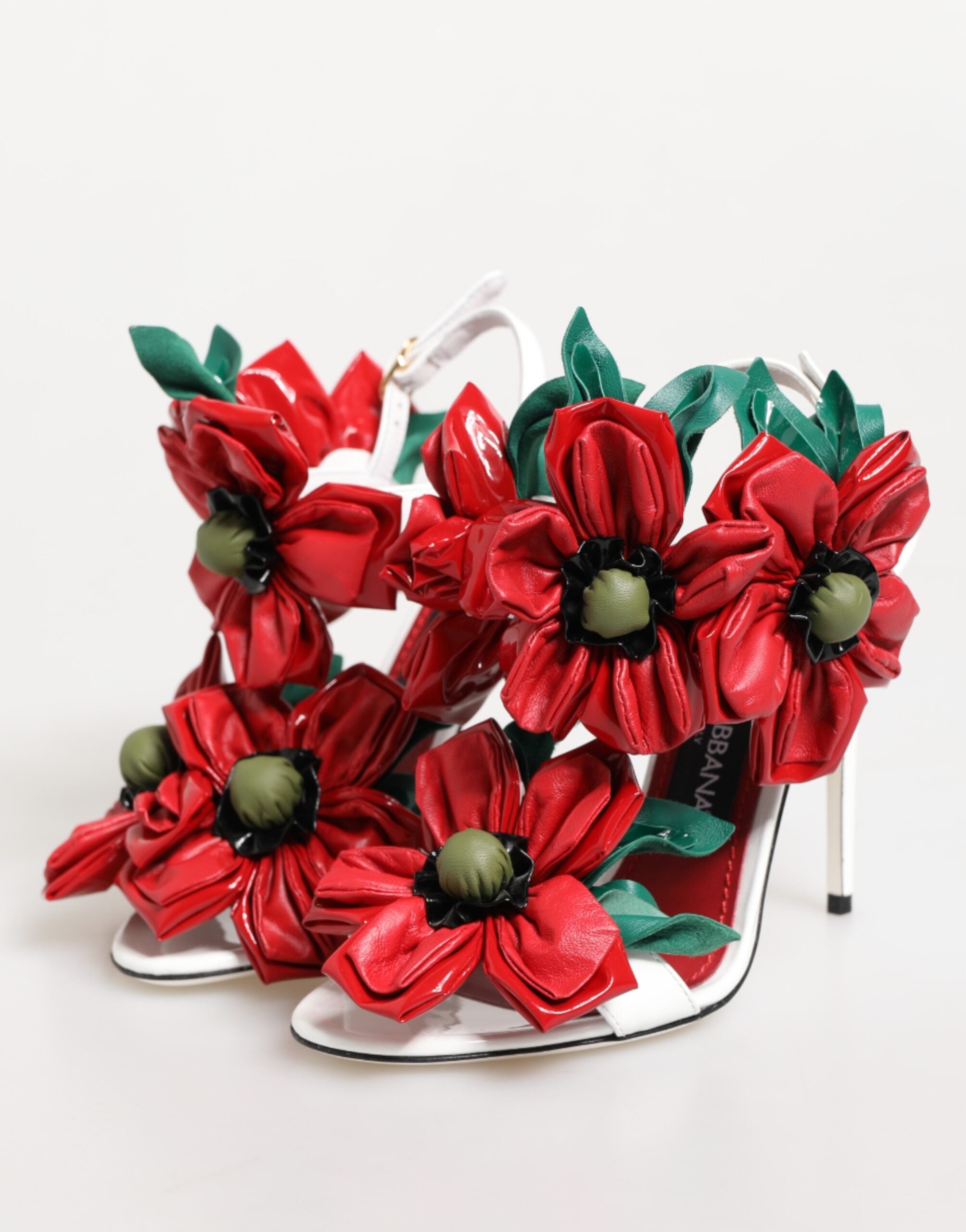 High-heeled shoes with red floral decorations on a white background